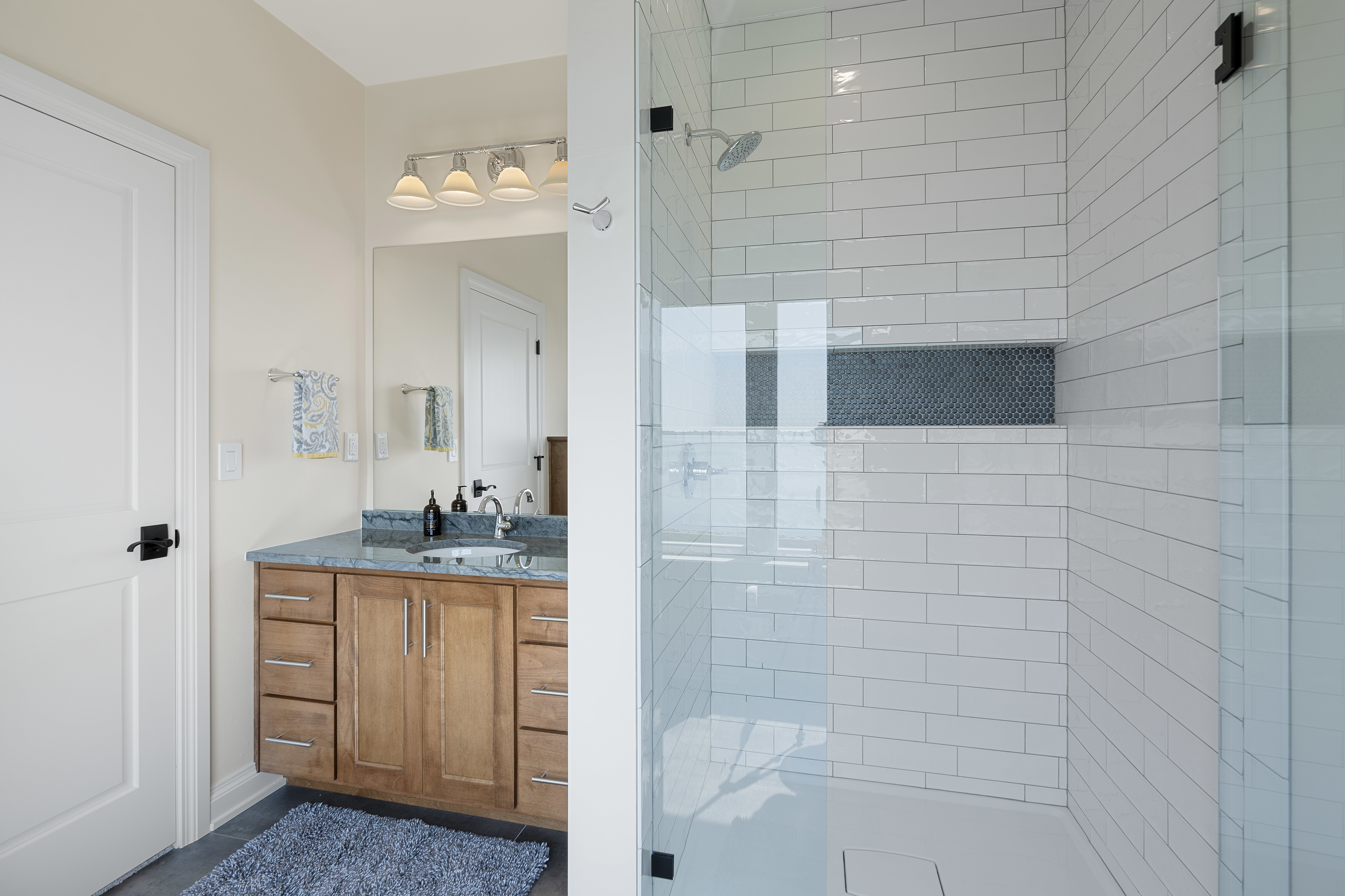 small bathroom after renovation with modern tile and grey sink cabinet 