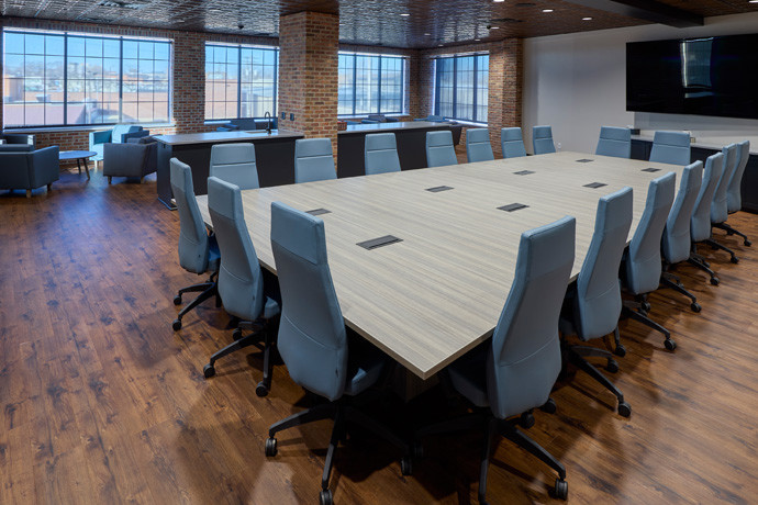 Office with wooden styled floor and blue chairs