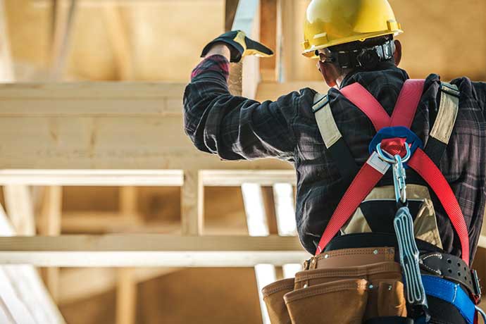 Framer in ladder with tool belt.